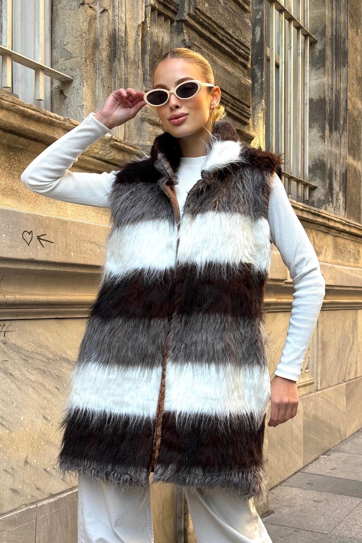 فيست طويل من الفرو الصناعي مخطط باللونين البني والأبيض بجيوب جلدية مفصلة باللون البيج