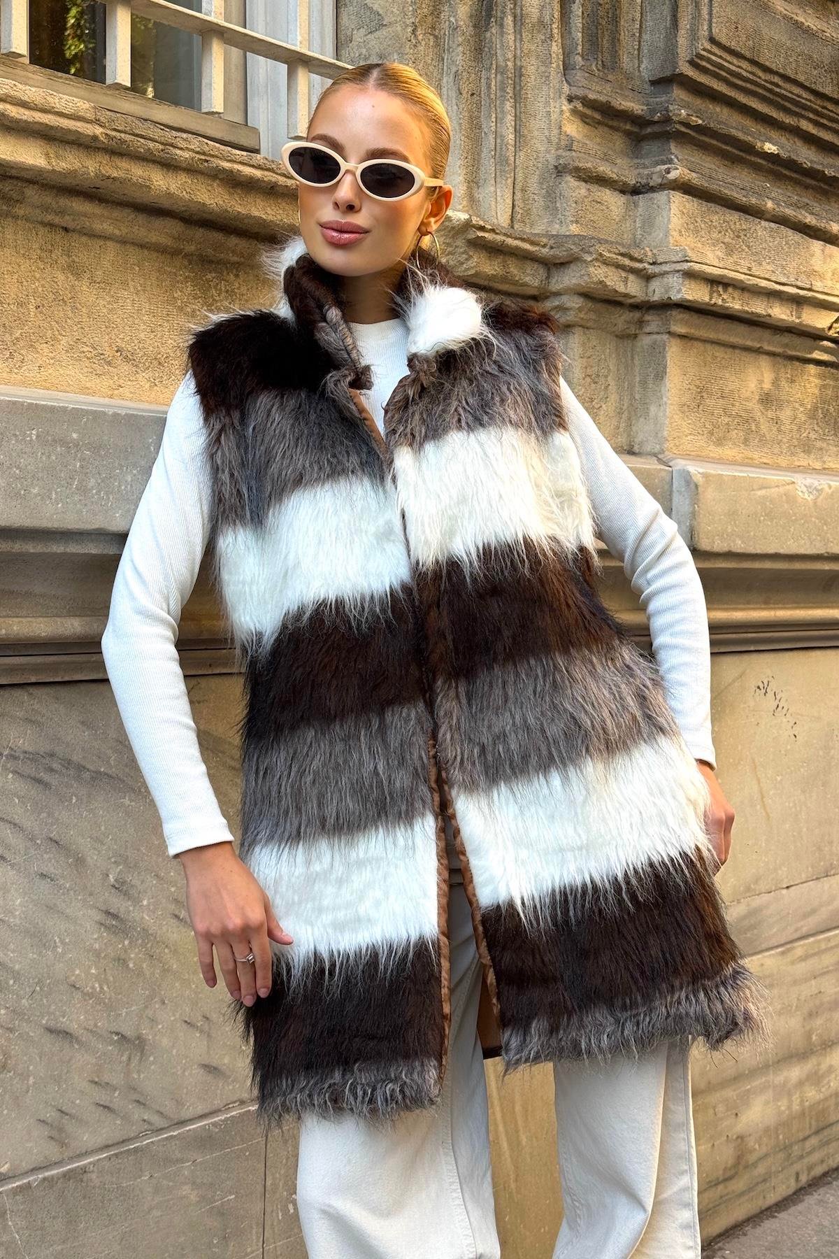 فيست طويل من الفرو الصناعي مخطط باللونين البني والأبيض بجيوب جلدية مفصلة باللون البيج