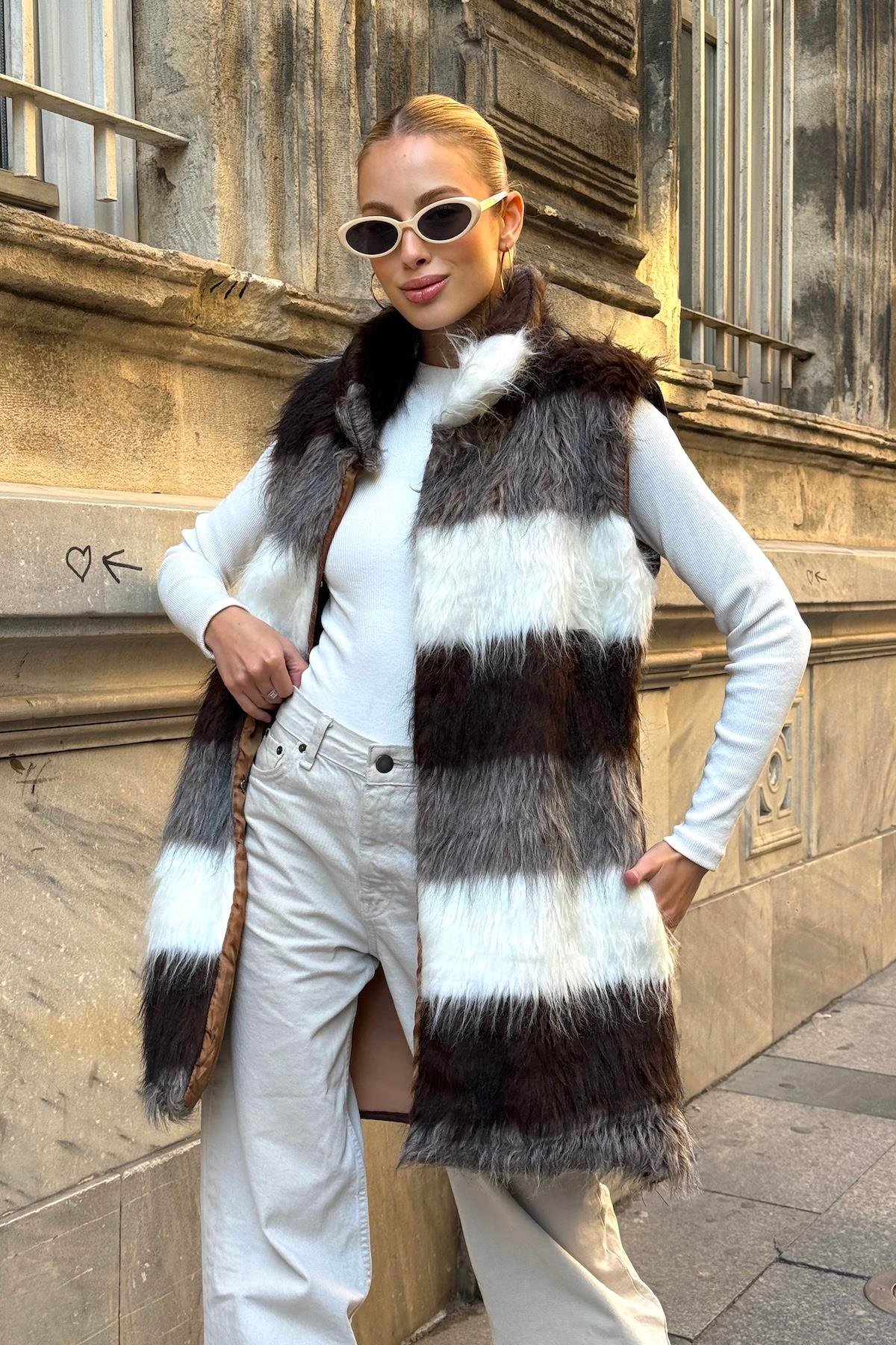 فيست طويل من الفرو الصناعي مخطط باللونين البني والأبيض بجيوب جلدية مفصلة باللون البيج