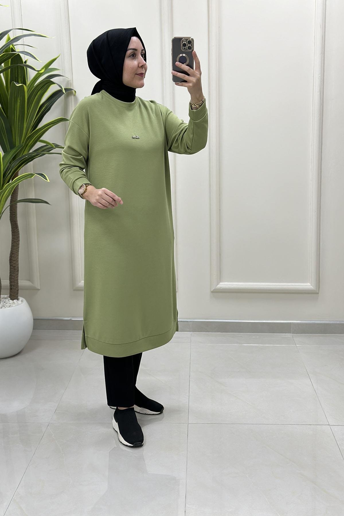 Tesettür Tunik ModelleriDüşük Omuz Önü Aksesuar Detaylı Uzun Kadın Tunik Fıstık Yeşili KADO 257420