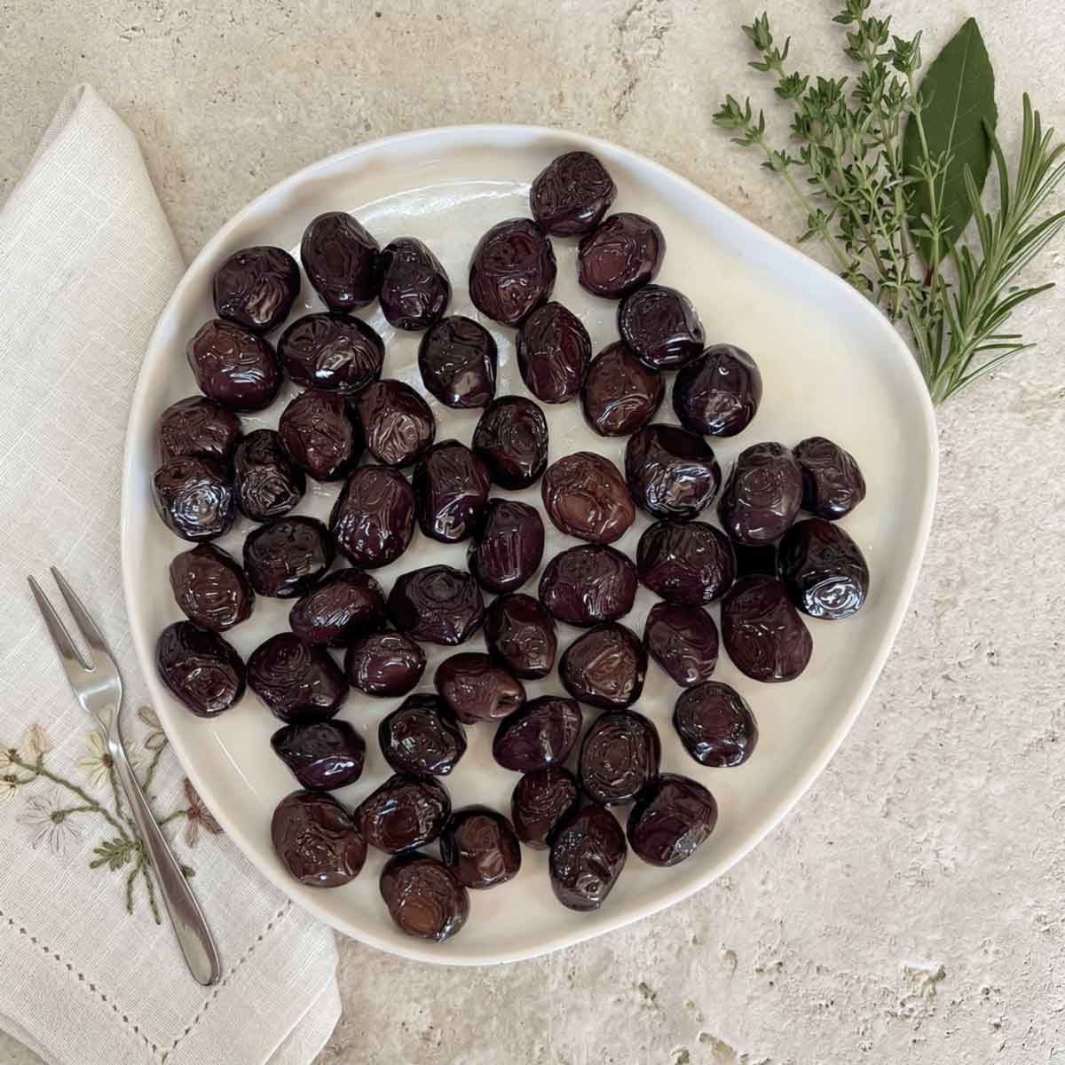 Tabakta sunulan Ayolis Premium Gurme Yağlı Salamura Siyah Zeytin L 650 g
