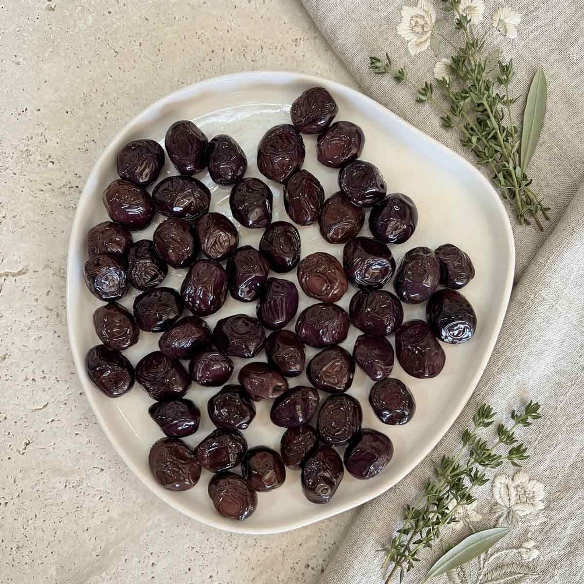 Tabakta sunulan Ayolis Premium Gurme Yağlı Salamura Siyah Zeytin L 950 g