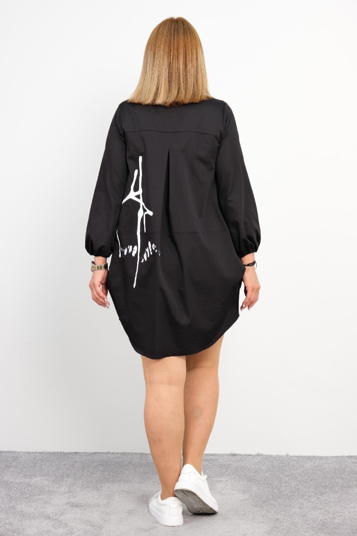  Bu görselde bir modelin önü ve arkası ayrı ayrı gösterilen siyah renkli bir elbise bulunmaktadır. Elbise düğme detaylı olup ön kısmında birkaç beyaz desen bulunmaktadır. Rahat bir kesime sahip olan elbisenin yan cepleri mevcuttur. Model, elbiseyi be