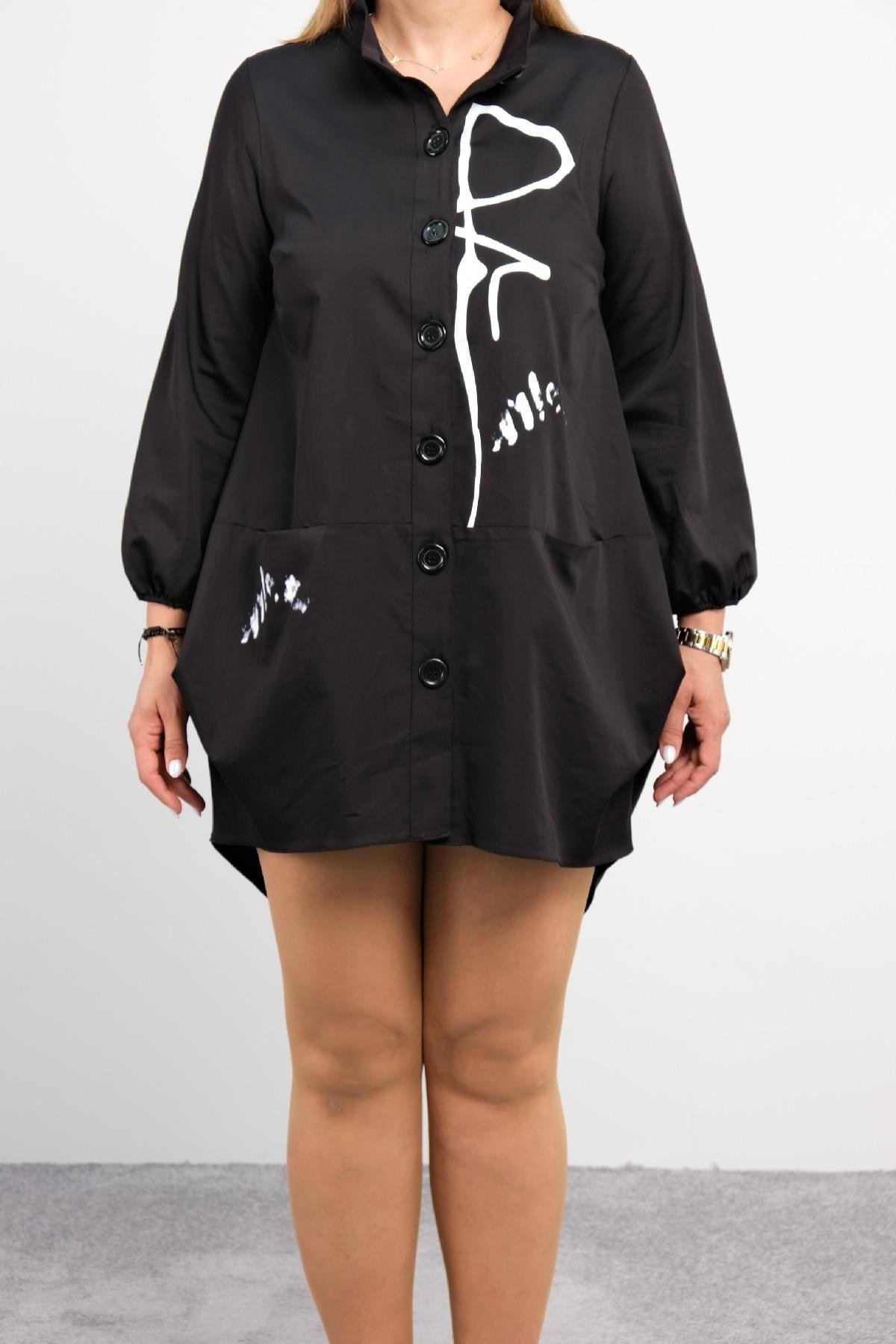  Bu görselde bir modelin önü ve arkası ayrı ayrı gösterilen siyah renkli bir elbise bulunmaktadır. Elbise düğme detaylı olup ön kısmında birkaç beyaz desen bulunmaktadır. Rahat bir kesime sahip olan elbisenin yan cepleri mevcuttur. Model, elbiseyi be