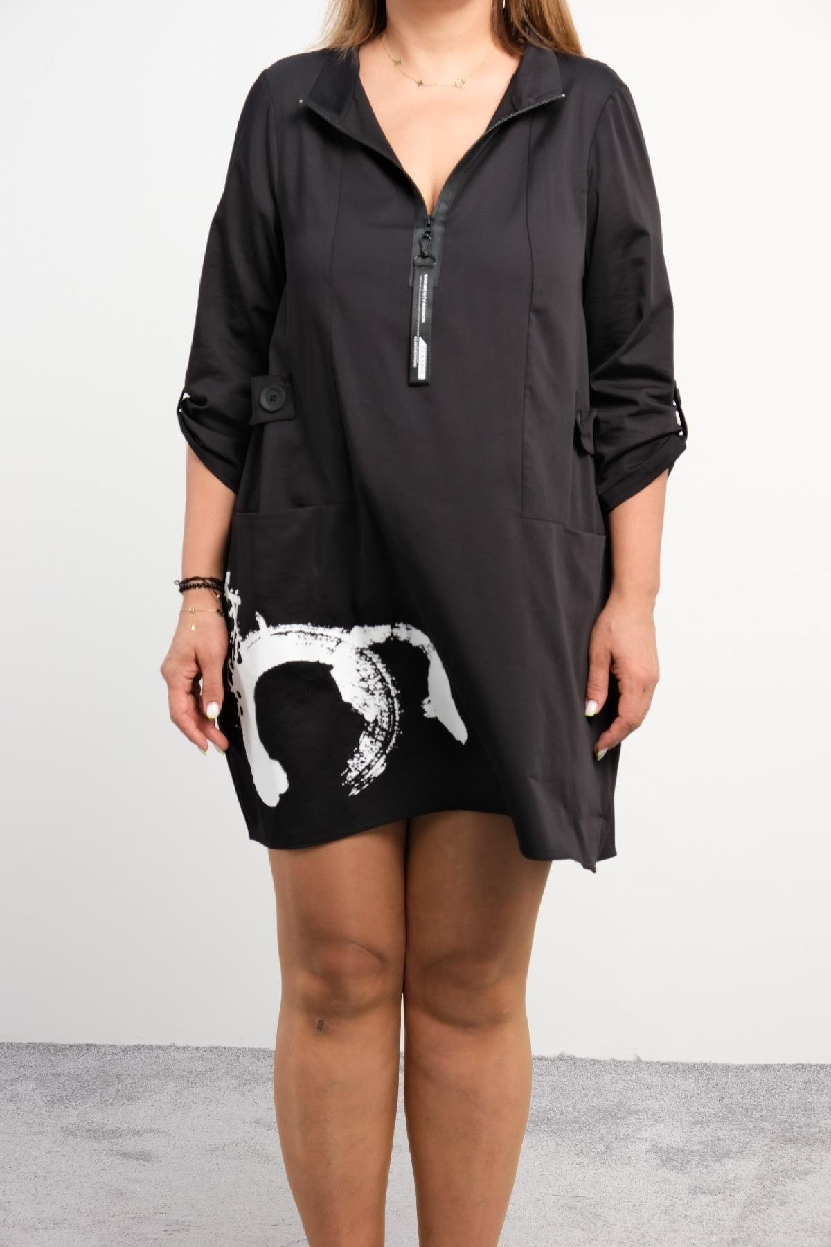  Bu siyah mini elbise, ön kısmında beyaz bir baskıya sahiptir. Uzun kollu ve kol kısımları kıvrılabilir. Fermuarlı bir yakaya sahip olup, rahat kesim olarak tasarlanmıştır. Pamuk veya pamuk karışımı malzemeden üretilmiştir ve oldukça rahattır.