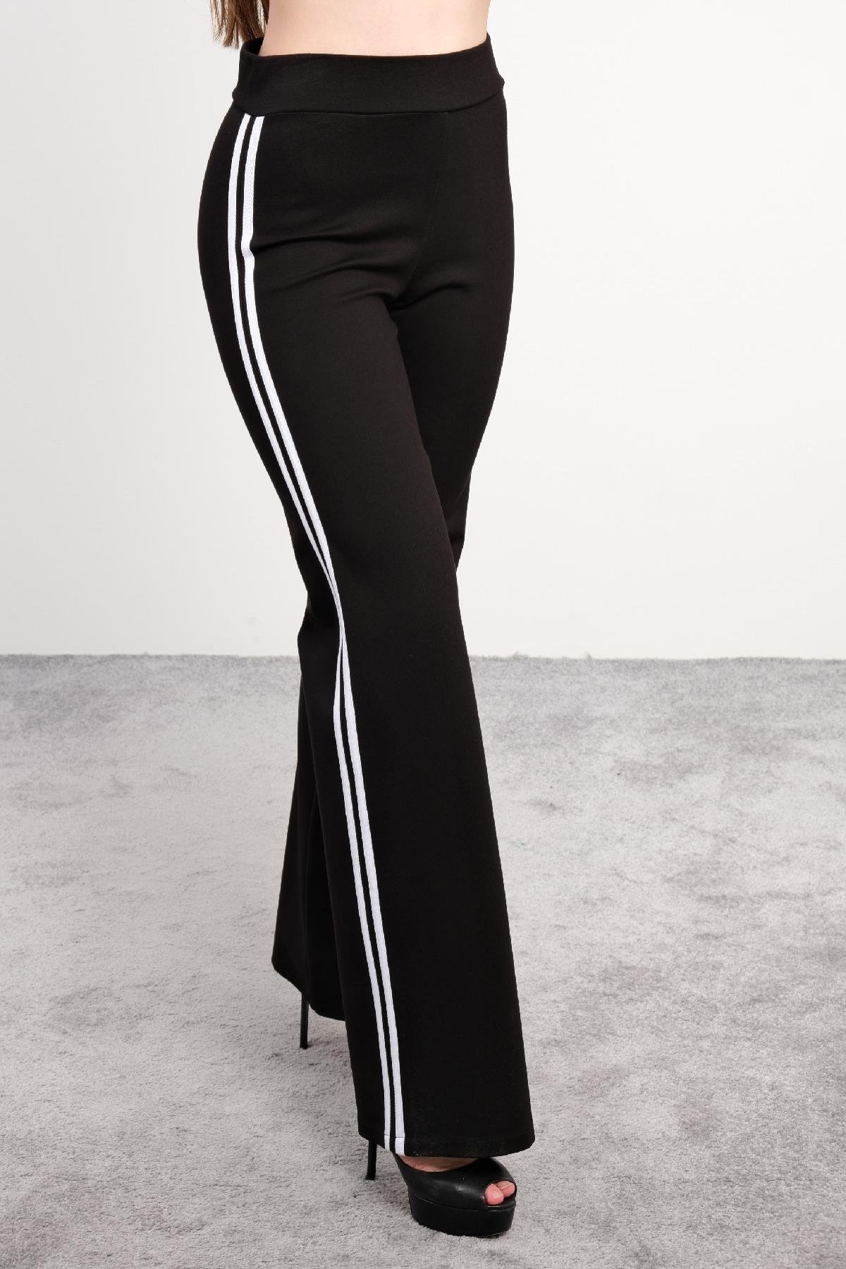  Siyah spor takım, spor sütyeni ve geniş paça pantolon. Spor sütyeni, sırt kısmında çapraz askılarla desteklenmiş ve hareket kabiliyetini artıran esnek bir yapıya sahiptir. Pantolon ise yandan beyaz şerit detaylara sahip olup, rahat kesimi ile spor v