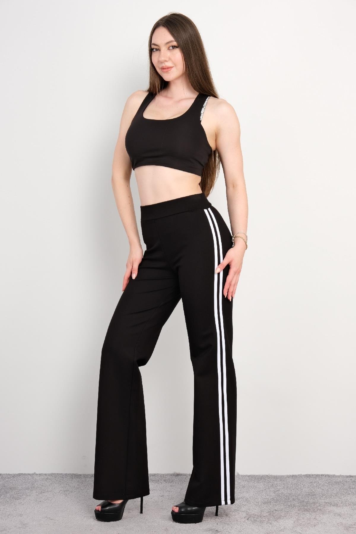  Siyah spor takım, spor sütyeni ve geniş paça pantolon. Spor sütyeni, sırt kısmında çapraz askılarla desteklenmiş ve hareket kabiliyetini artıran esnek bir yapıya sahiptir. Pantolon ise yandan beyaz şerit detaylara sahip olup, rahat kesimi ile spor v