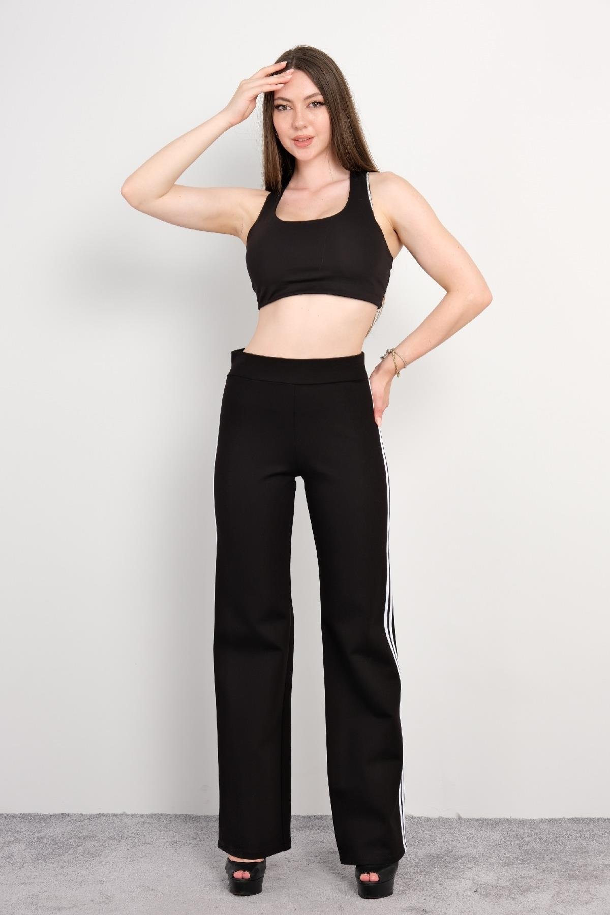  Siyah spor takım, spor sütyeni ve geniş paça pantolon. Spor sütyeni, sırt kısmında çapraz askılarla desteklenmiş ve hareket kabiliyetini artıran esnek bir yapıya sahiptir. Pantolon ise yandan beyaz şerit detaylara sahip olup, rahat kesimi ile spor v