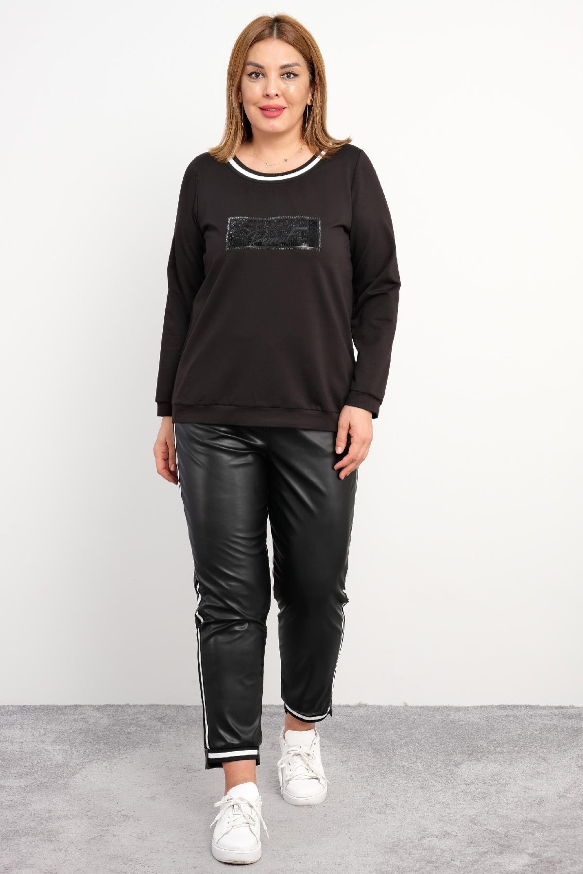 Bu büyük beden kadın ikili takım, rahat ve şık bir seçenektir. Sweatshirt siyah renkte olup, ön kısmında parlak siyah bir detay bulunmaktadır. Yuvarlak yaka tasarımı, beyaz ve siyah çizgili bir şerit ile çevrelenmiştir. Sweatshirt, manşetleri ve etek ucu 