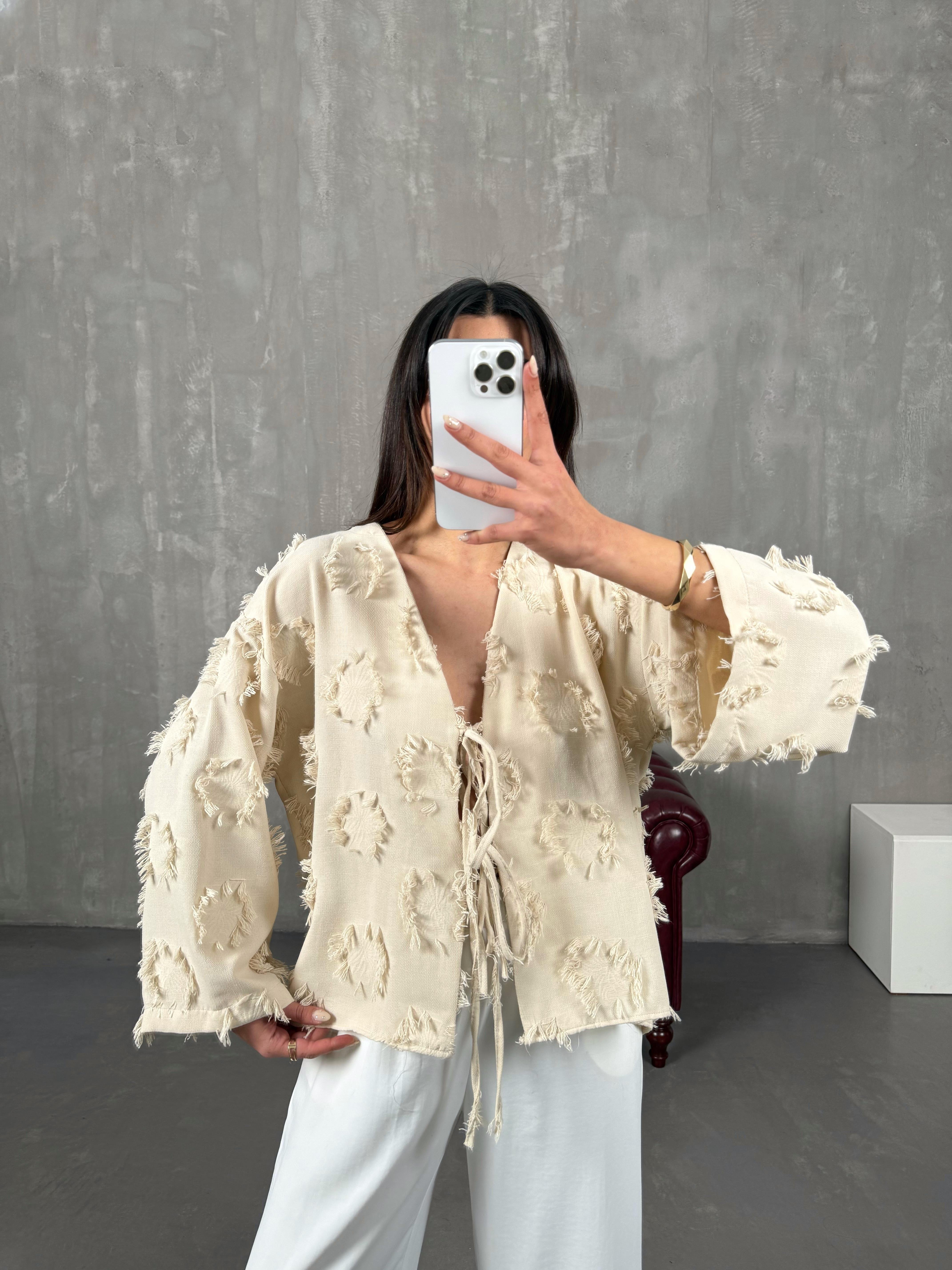 زينيت قميص كتان بيج بربّاط وتفاصيل شراشيب