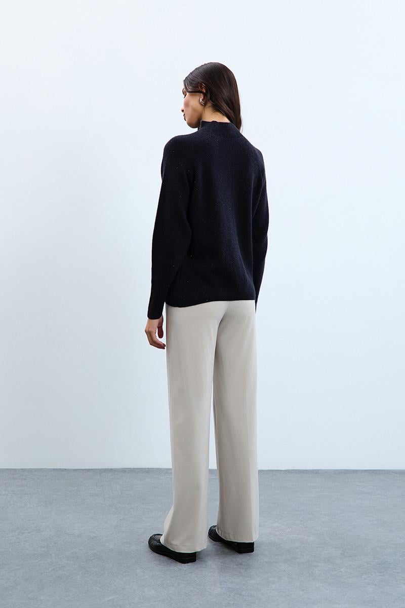 Свитер с воротником-водолазкой, вязанными деталями и пушистыми вставками.