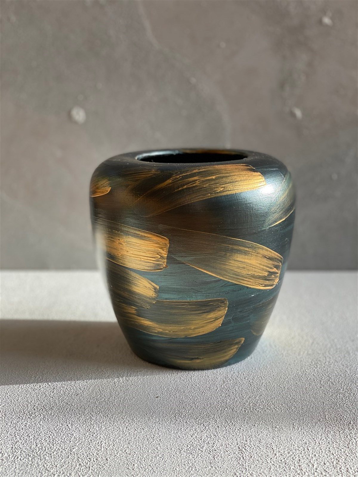 مزهرية خضراء بتفاصيل ذهبية